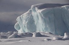 Sun on iceberg with dark skies behind