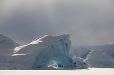 Sun on iceberg with dark skies behind