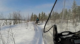 Snowmobile heading down to lake