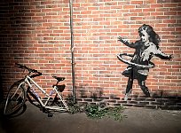 Girl with bicycle at Banksy museum in Madrid