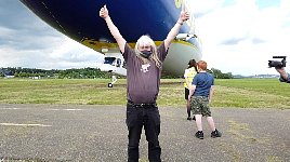 Happy jubilar in front of Zeppelin