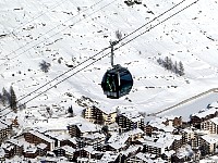 View down to Zermatt and cable car cabin from winter hiking trail above Zermatt