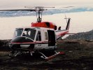 Helicopter perched beside glacier