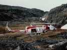 Helicopters perched beside glacier