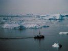 Icebergs and boat at coast at Ilulissat, Greenland