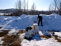 Digging snow hole for dog food