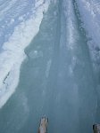 Water filled snowmobile trail on lake