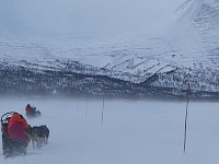 Crouching behind the sled to be out of the wind