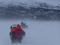 Crouching behind the sled to be out of the wind