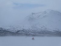 Crouching behind the sled to be out of the wind