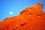 Moon over rock, coloured red by setting sun